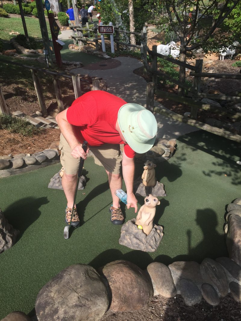 A player contorting over an awkward lie