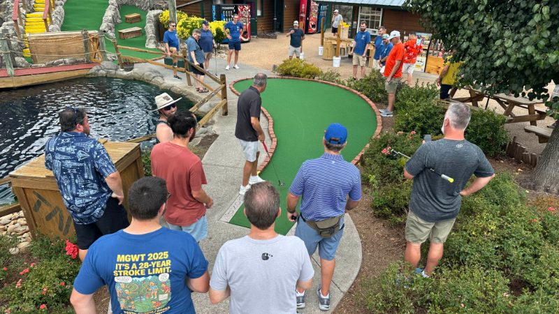 A large group crowded around a green