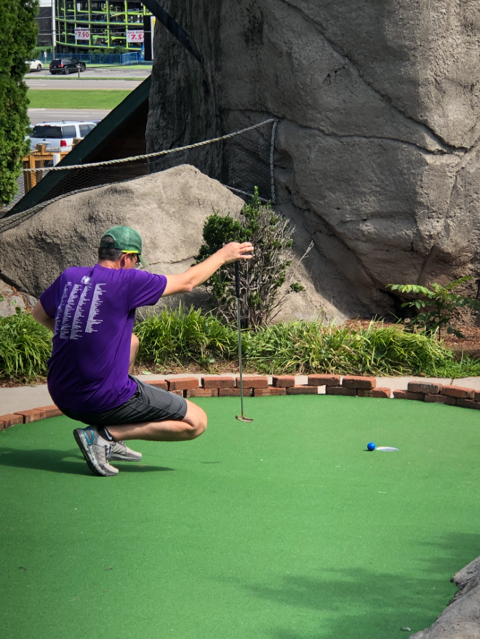 A player crouched behind the ball reading a putt